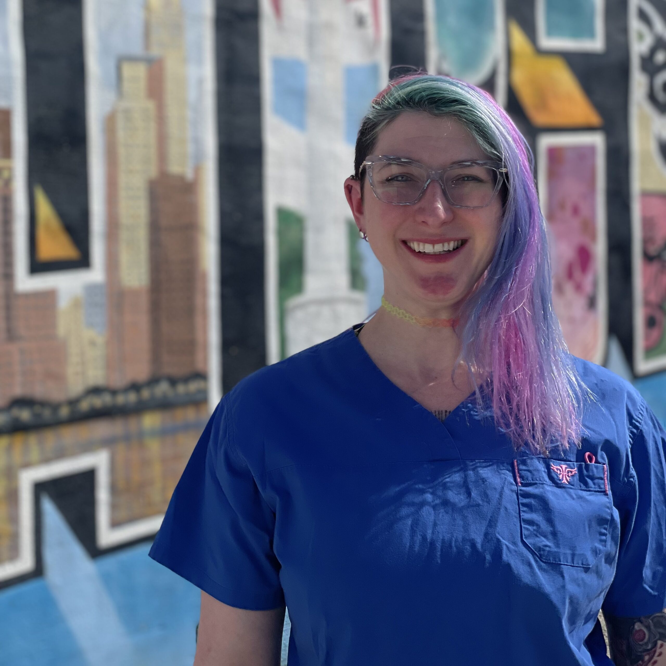 Brooce vet tech standing in front of a Chicago mural